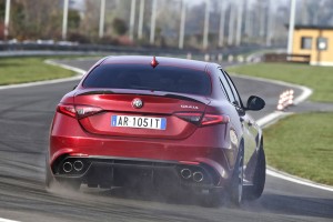 Roter Alfa Romeo Giulia Quadrifoglio QV driftend auf Rennstrecke von hinten